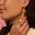 Gouden oorbellen met ronde, roze steen en zirkonia steentjes. Gedragen op een model.