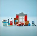 LEGO Duplo Cars set: rode Lightning McQueen, doktersgarage, pompstation en medische attributen, op een blauwe ondergrond.