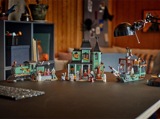 Un garçon joue avec des constructions LEGO : manoir hanté, train fantôme et bateau fantôme.