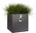 Een vierkante, grijze plantenbak gevuld met lang, groen gras en een Elho label.