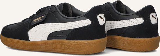 Achterkant van zwarte Puma Palermo sneakers met witte Puma-streep en gummi zool.