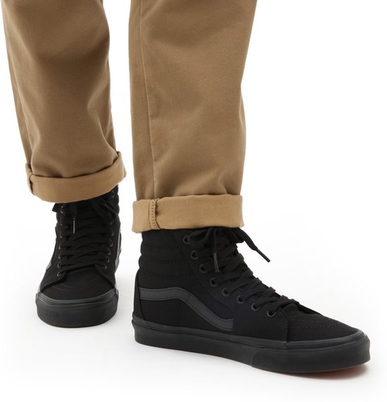 Vans SK8-Hi sneakers gedragen onder een beige broek met opgerolde zomen.