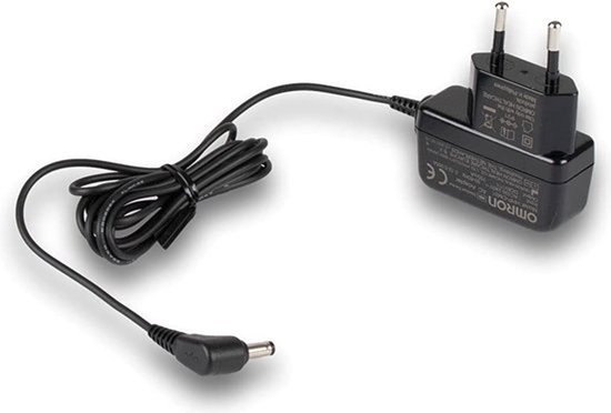 Zwarte Omron AC adapter met metalen stekkers en een gebogen connector. De kabel is opgerold.