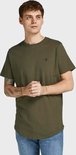 Man met olijfgroen t-shirt met kleine zwarte logoprint en spijkerbroek.