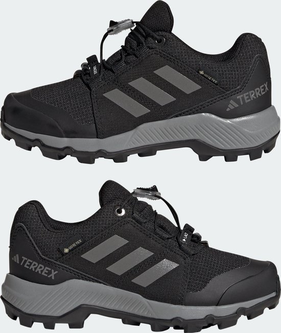 Twee zwarte kinderschoenen met grijze Adidas-strepen, GORE-TEX-logo en grijze zool.