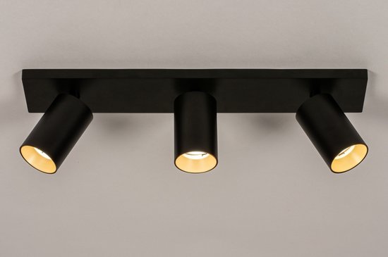 Plafonnier noir avec trois spots, les extérieurs à intérieur doré, le central allumé.
