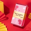 Roze geschenkdoos met hartjes, ballonnen, confetti en de tekst 'BEST WISHES FOR YOU'.