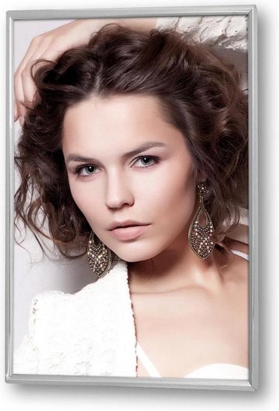 Femme aux cheveux bruns et bouclés, grandes boucles d'oreilles et un haut blanc.