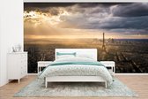 Behang - Fotobehang skyline over Parijs met heldere zonnestralen die de Eiffeltoren verlichten - Breedte 395 cm x hoogte 220 cm