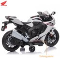 Witte Honda CBR 1000RR elektrische kindermotor met rijpedaal, deels van de zijkant gezien.