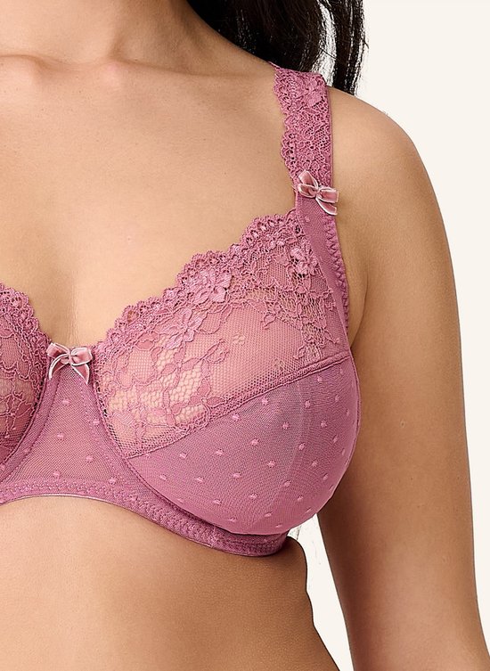 Close-up van de roze kanten beha met stippelpatroon en strikdetail.