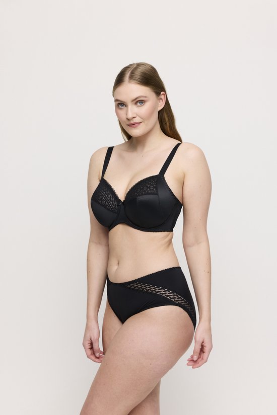 Model draagt een zwarte beugelbeha met kanten details en bijpassende zwarte slip.