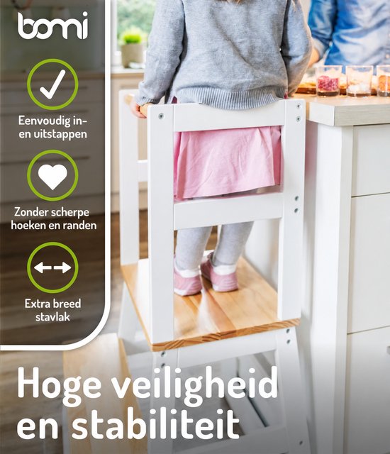 Meisje in grijze vest en roze jurk, voeten zichtbaar, staat in een witte leertoren. Met "Extra breed stavlak".