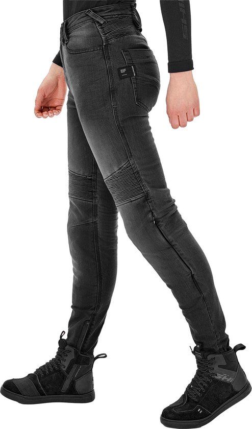 Grijze dames motorjeans in beweging, met geribbelde knieën, enkels en gedragen met sneakers.