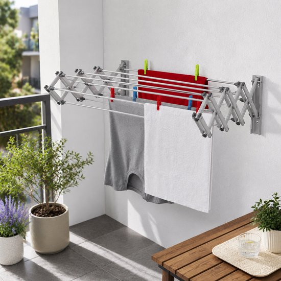 Uitschuifbaar aluminium droogrek aan muur met rode en grijze wasgoed.