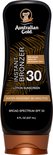Zwarte fles Australian Gold Instant Bronzer met SPF 30. Tekst: 'Non-Greasy Quick Dry Antioxidant Rich 30 Lotion Sunscreen Water Resistant (80 Minutes) Broad Spectrum SPF 30 8 FL OZ (237 mL)'.