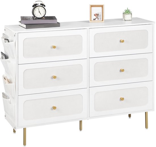 Wit dressoir met 6 lades met textiel voorkant en gouden knoppen, staand op gouden pootjes. Links een zijtas met vakken.