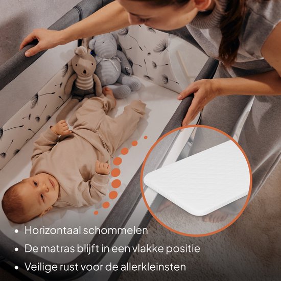 Bébé dans un lit cododo beige à motif floral, à côté d'une femme. Gros plan montrant les détails du matelas.