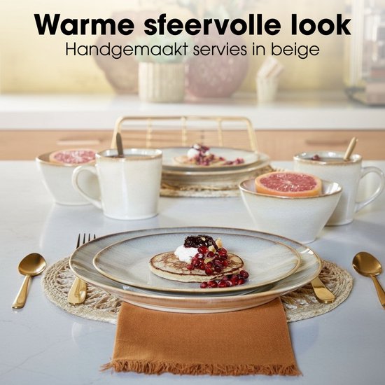 Beige servies met pannenkoeken, fruit en ontbijtgranen op een tafel met gouden bestek.
