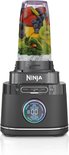 Zwarte Ninja blender met een beker gevuld met fruit, bessen, spinazie en ijs. De basisunit heeft een digitaal display.