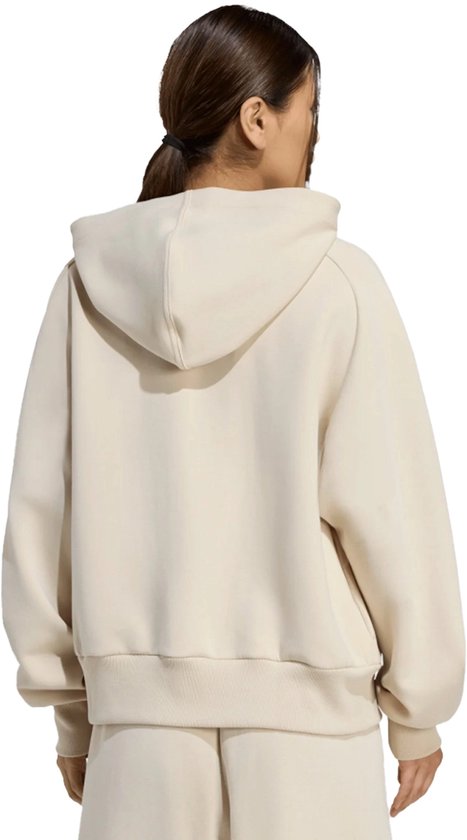 Aanzicht op de rug van een beige adidas vest met capuchon op een model.