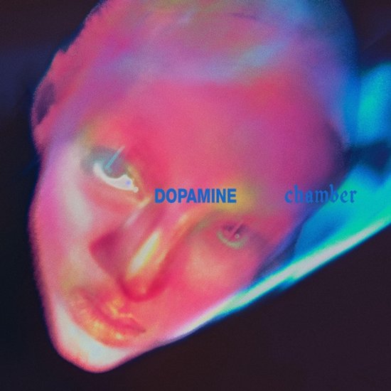 Image abstraite avec une lueur rose et bleue, avec le texte 'DOPAMINE chamber'.