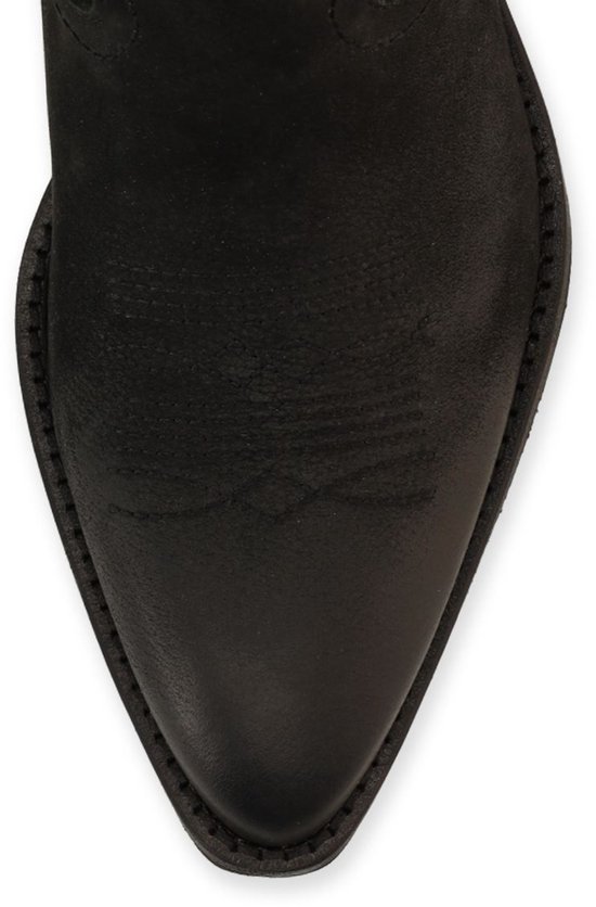 Close-up van de spitse neus van een zwarte nubuck cowboylaars.