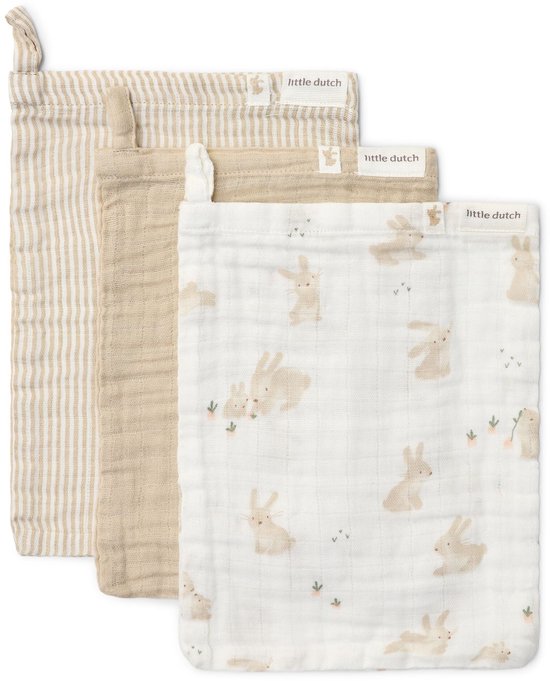 Drie washandjes in de kleuren beige en wit. Eén met verticale strepen, één effen beige, en één met een print van babykonijntjes.