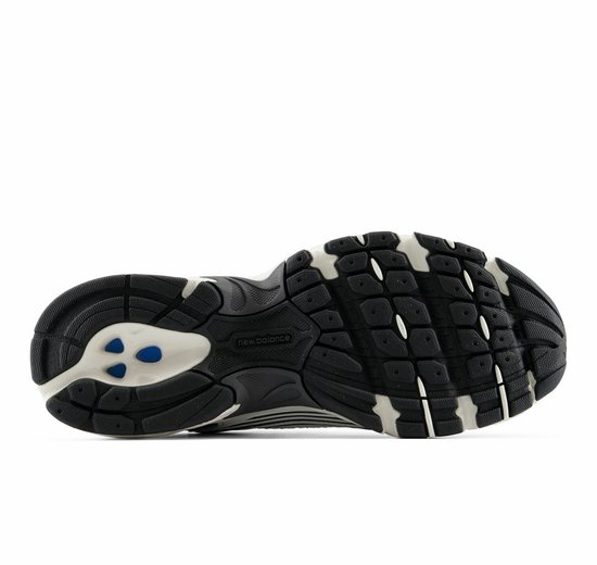 Zool van witte en grijze New Balance sneakers met een zwart profiel.