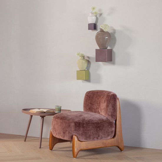 Bruine fluwelen fauteuil naast een roze bijzettafel met een boek en kopje.