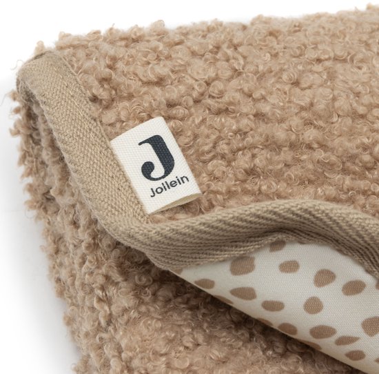 Close-up van de bruine teddy stof van de luierwisselmat, met beige stippenpatroon aan de binnenkant.