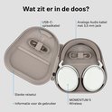 Zwarte en witte Sennheiser MOMENTUM 5 Wireless koptelefoon in een beige reissetui, met USB-C oplaadkabel en analoge audiokabel.