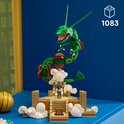 LEGO Rayquaza bouwpakket met een figuur op een platform omringd door wolken. De groene draak heeft rode accenten en gouden ringen.