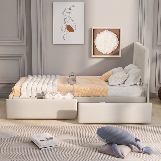 Wit bed met gecapitonneerd hoofdbord en lades, met beddengoed en decoratie.