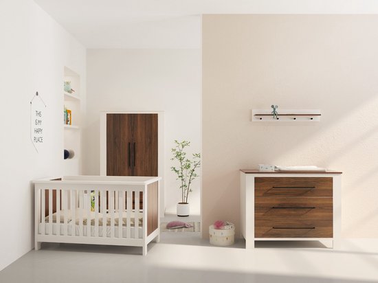 Babykamer met wit ledikant, een commode met drie walnoothouten laden en een kast in dezelfde stijl.