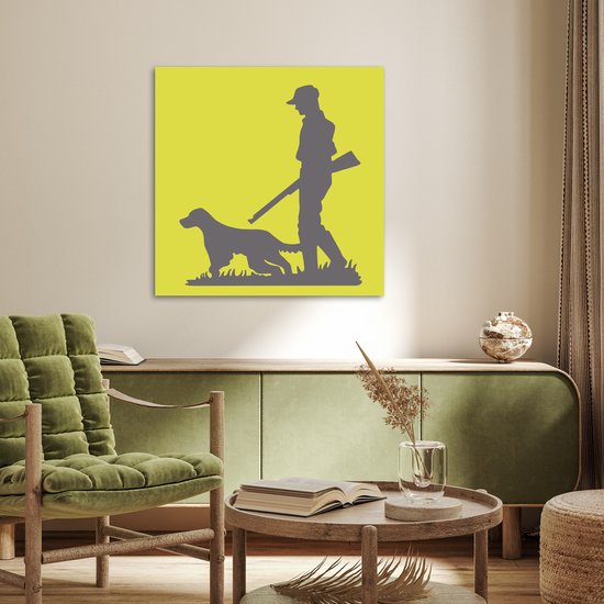 Een poster met een jager en hond op een gele achtergrond, hangend boven een groene kast in een woonkamer.