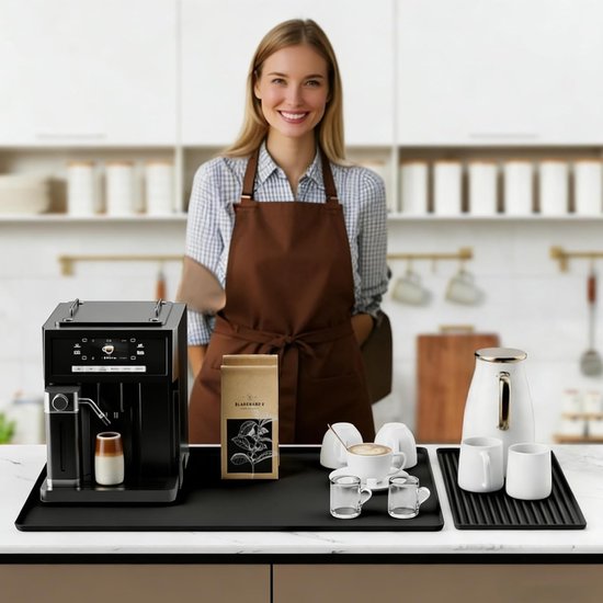 Zwarte koffiebarmat met een zwarte volautomatische espressomachine, een zak koffiebonen, een witte waterkoker, twee witte melkkannetjes en twee espressokopjes.