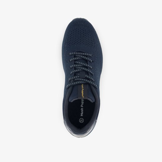 Bovenkant van een donkerblauwe sneaker met veters en het Hush Puppies logo op de binnenzool.