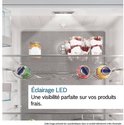 Binnenzijde koelkast met LED verlichting, potje jam, schaaltjes met dessert en drie blikjes in een houder. Tekst: 'LED verlichting Perfect zicht op uw verse producten.'
