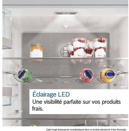 Binnenzijde koelkast met LED verlichting, potje jam, schaaltjes met dessert en drie blikjes in een houder. Tekst: 'LED verlichting Perfect zicht op uw verse producten.'
