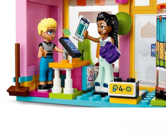 Deux figurines près d'un comptoir avec des téléphones, l'une aux cheveux blonds, l'autre aux cheveux tressés et taches de naissance.