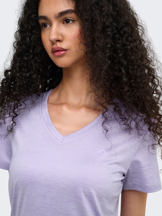 Model draagt een lichtpaars V-hals T-shirt met een klein logo op de borst. Close-up van voren.