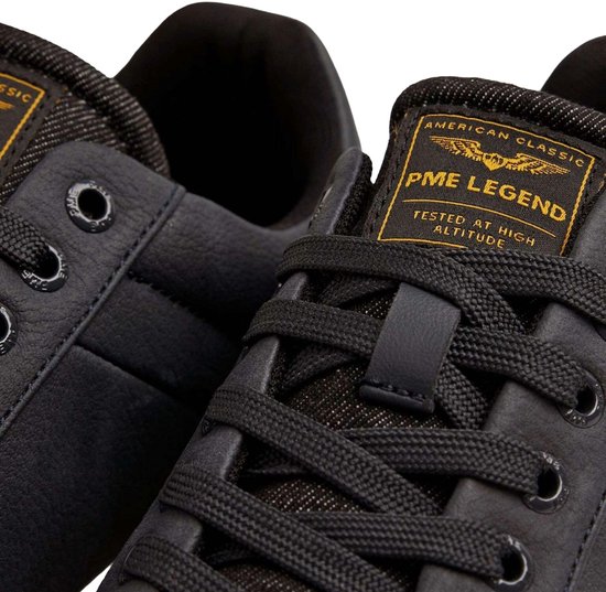 Twee donkerblauwe PME Legend sneakers met witte zolen, close-up van het label.