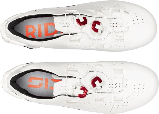 Bovenaanzicht van twee witte Sidi wielrenschoenen met rode sluitingsmechanismen en Sidi-logo binnenin.