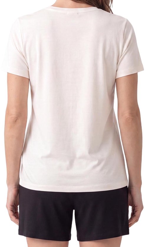 Vrouw draagt achterkant crème T-shirt en zwarte short.