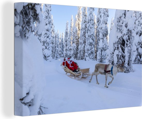 Canvas Schilderij Rendier trekt de kerstman op een slee in Lapland - 120x80 cm - Wanddecoratie