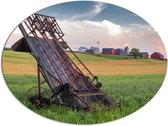 WallClassics - Dibond Ovaal - Ouderwetse Oogstmachine bij Boerderij - 108x81 cm Foto op Ovaal (Met Ophangsysteem)