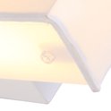 Close-up van de witte stoffen kap van een wandlamp, met een transparante sluiting en zacht verlichte binnenkant.