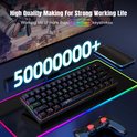 Zwart compact toetsenbord met RGB-verlichting, geplaatst op een gloeiende mat.