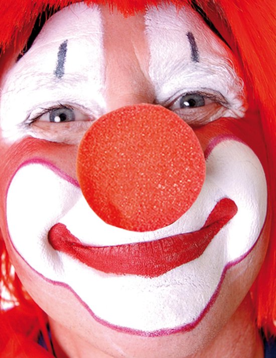 Close-up van een gezicht van een clown met rode pruik, witte schmink en een rode neus.
